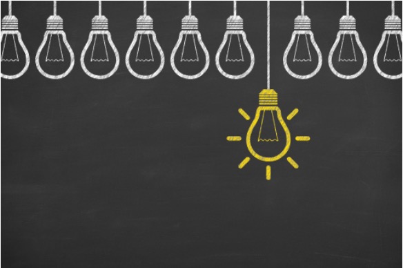 A yellow light bulb standing out among rows of white bulbs