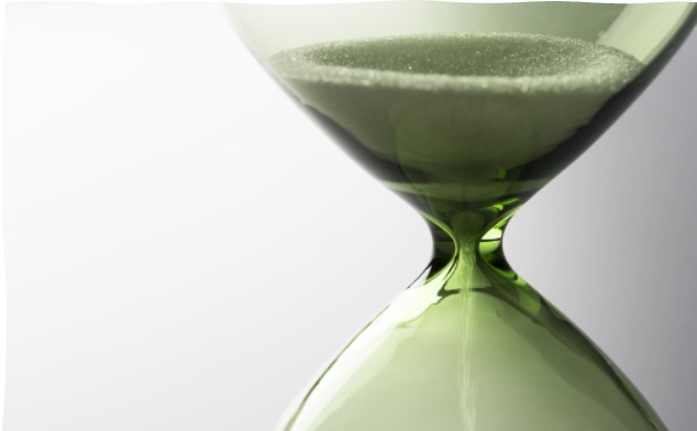 Sand moving through a green hourglass